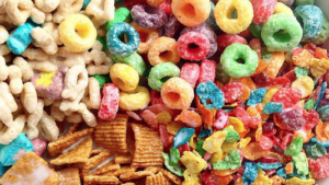 Close-up of colorful sugary cereals including Fruit Loops, Frosted Flakes, and Lucky Charms